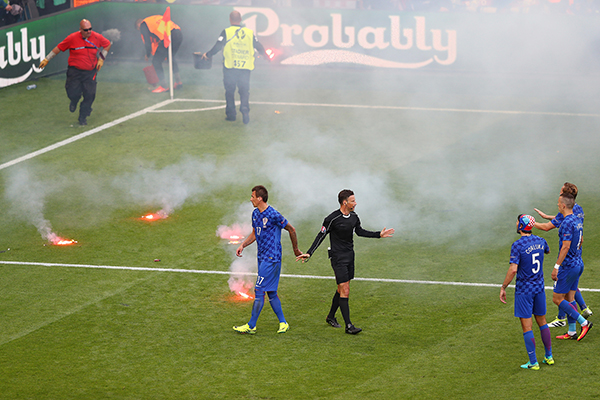 球迷向场内投掷烟花至比赛中断。